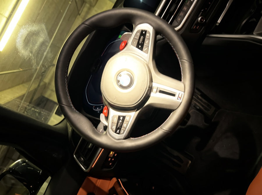 Illustration of a bad photo: tilted steering wheel with flash glare over the airbag