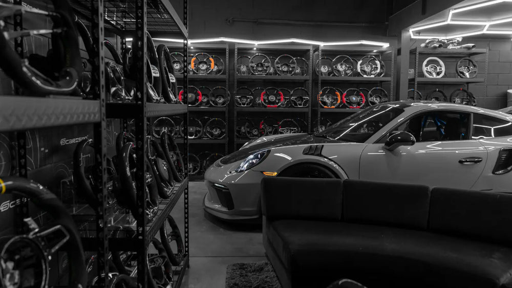 The Carismo showroom in Staten Island: walls of steering wheels behind a Porsche 911 GT3